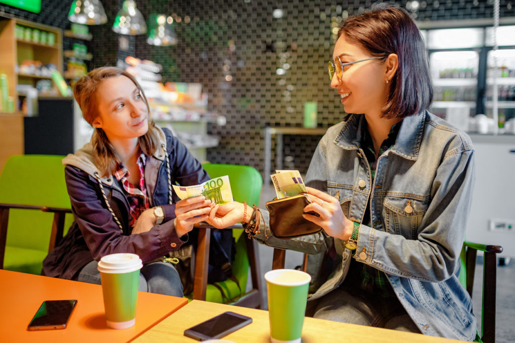 a woman giving money to a friend